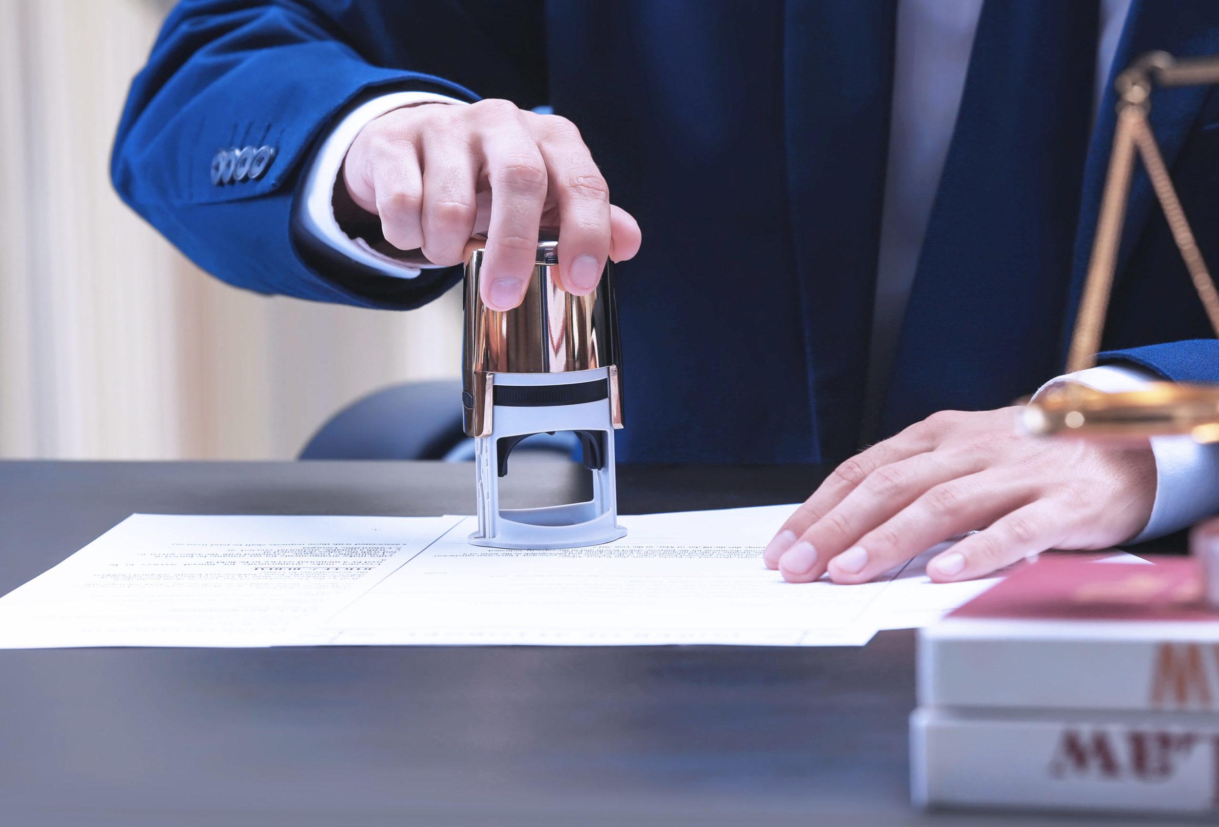 Notar setzt Stempel unter Dokument