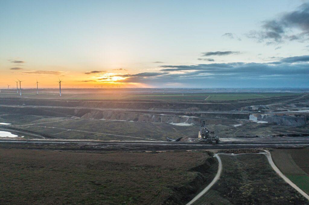 Sonnenuntergang über dem Tagebau Garzweiler im Rhein-Kreis Neuss mit weiter Landschafts- und Tagebaustruktur im Abendlicht.